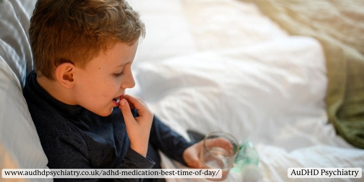 Young boy taking ADHD medication in the morning while sitting in bed with a glass of water in hand