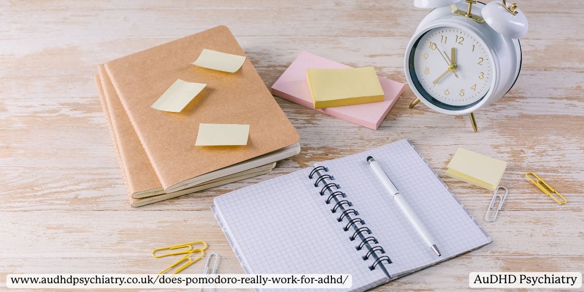 Open notebook and sticky notes beside an alarm clock, symbolising ADHD planning tools for teens using Pomodoro.