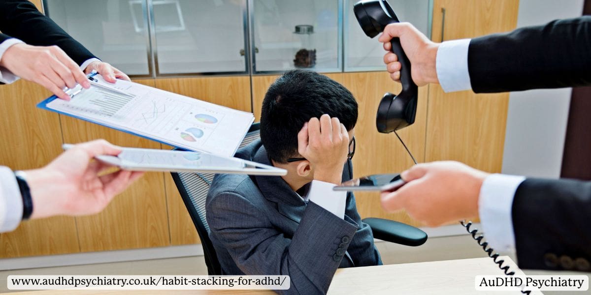 Overwhelmed office worker surrounded by demands symbolising ADHD executive dysfunction