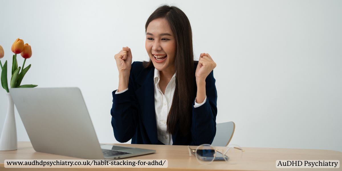 Smiling woman celebrating a productivity win while working on a laptop symbolising ADHD reward sensitivity