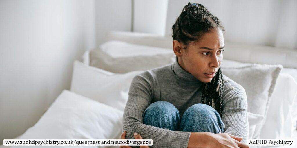 Person with ADHD sitting alone on bed appearing reflective and anxious