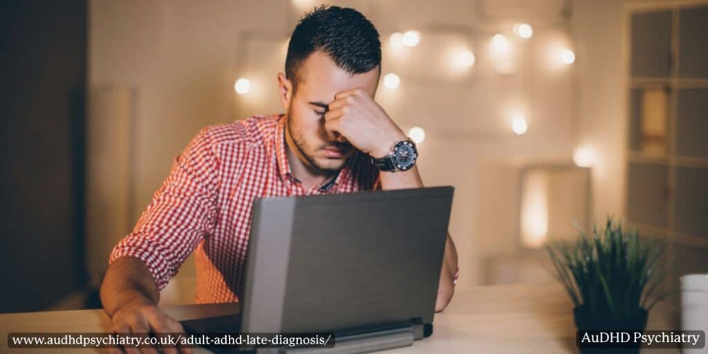 Stressed man at laptop representing struggles linked to adult ADHD late diagnosis