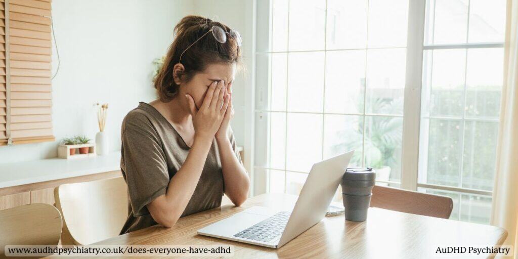 Woman feeling overwhelmed at laptop showing ADHD struggles beyond parenting myths