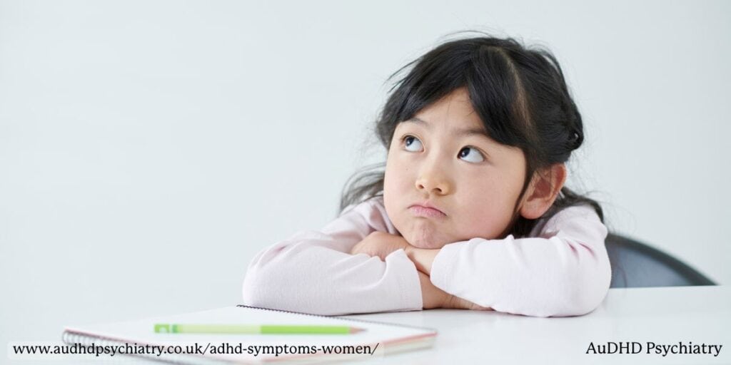 Young girl daydreaming at table – early ADHD symptoms in girls often overlooked