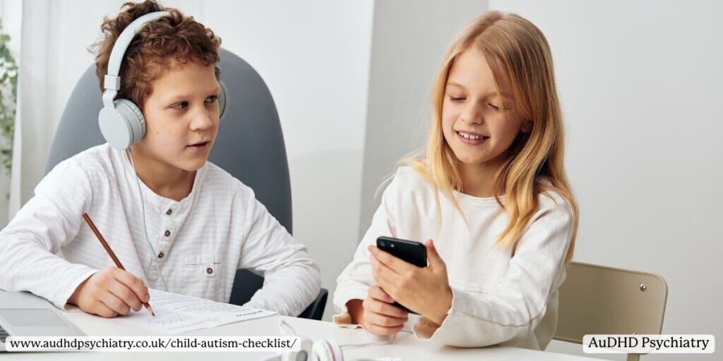Children working at a desk, one wearing headphones, illustrating sensory processing differences included in a child autism checklist