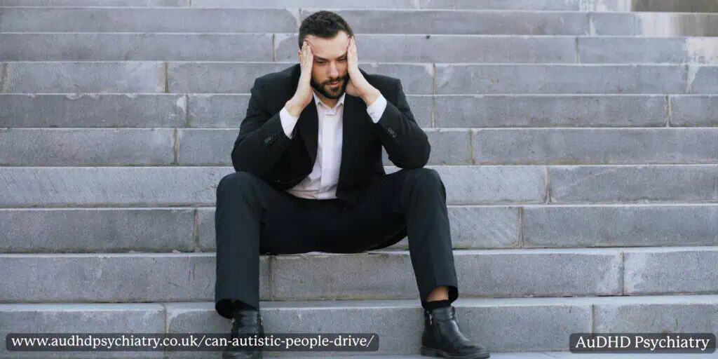 Man sitting stressed on steps, symbolising anxiety and overwhelm linked to driving challenges in autism