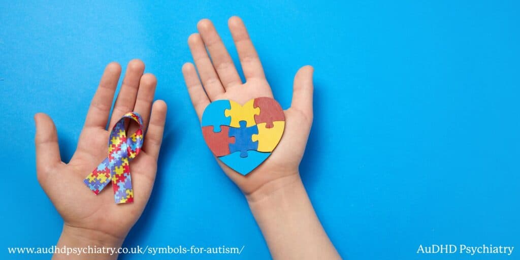Hands holding autism puzzle ribbon and heart, representing awareness and support
