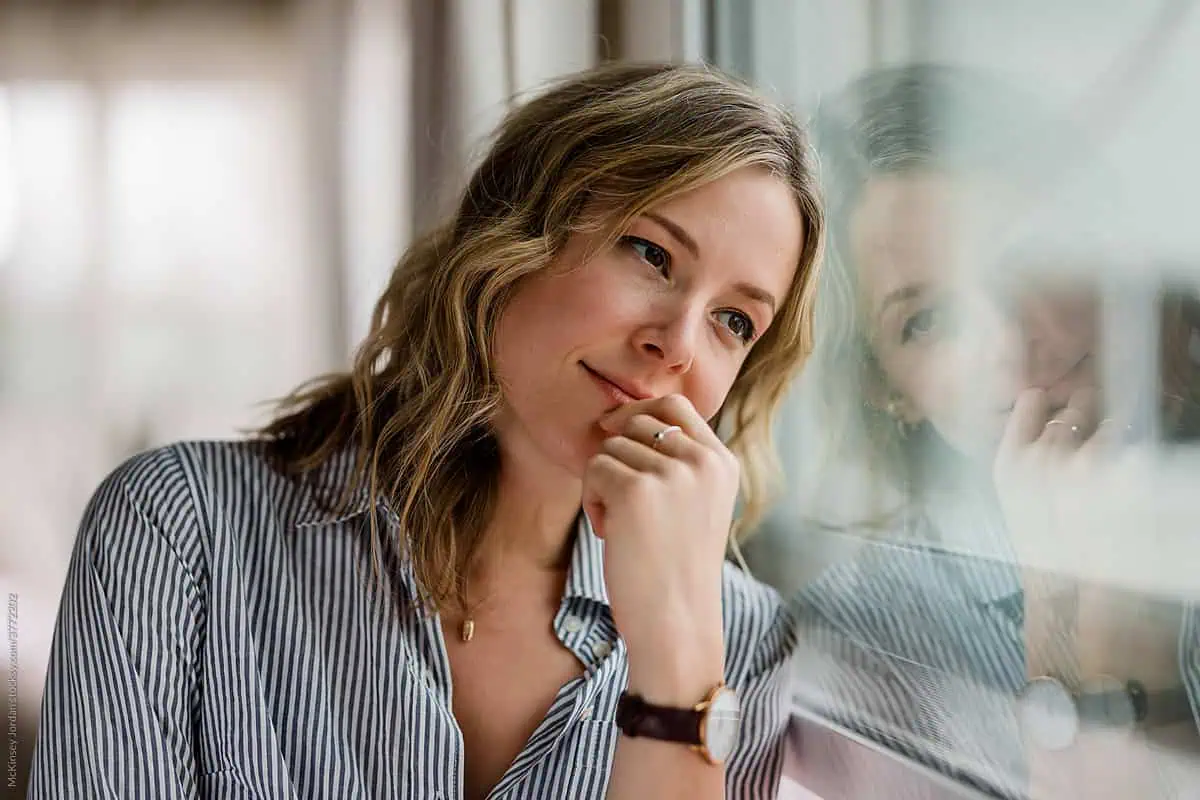 Young woman in a white shirt engaging in a therapy session with a psychiatrist in a comfortable, modern office setting.