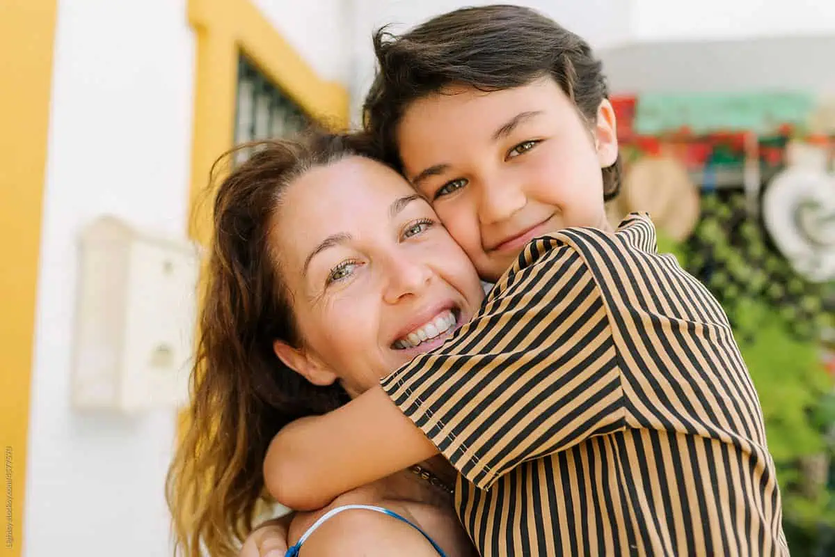 Mother and son hugging and smiling outdoors