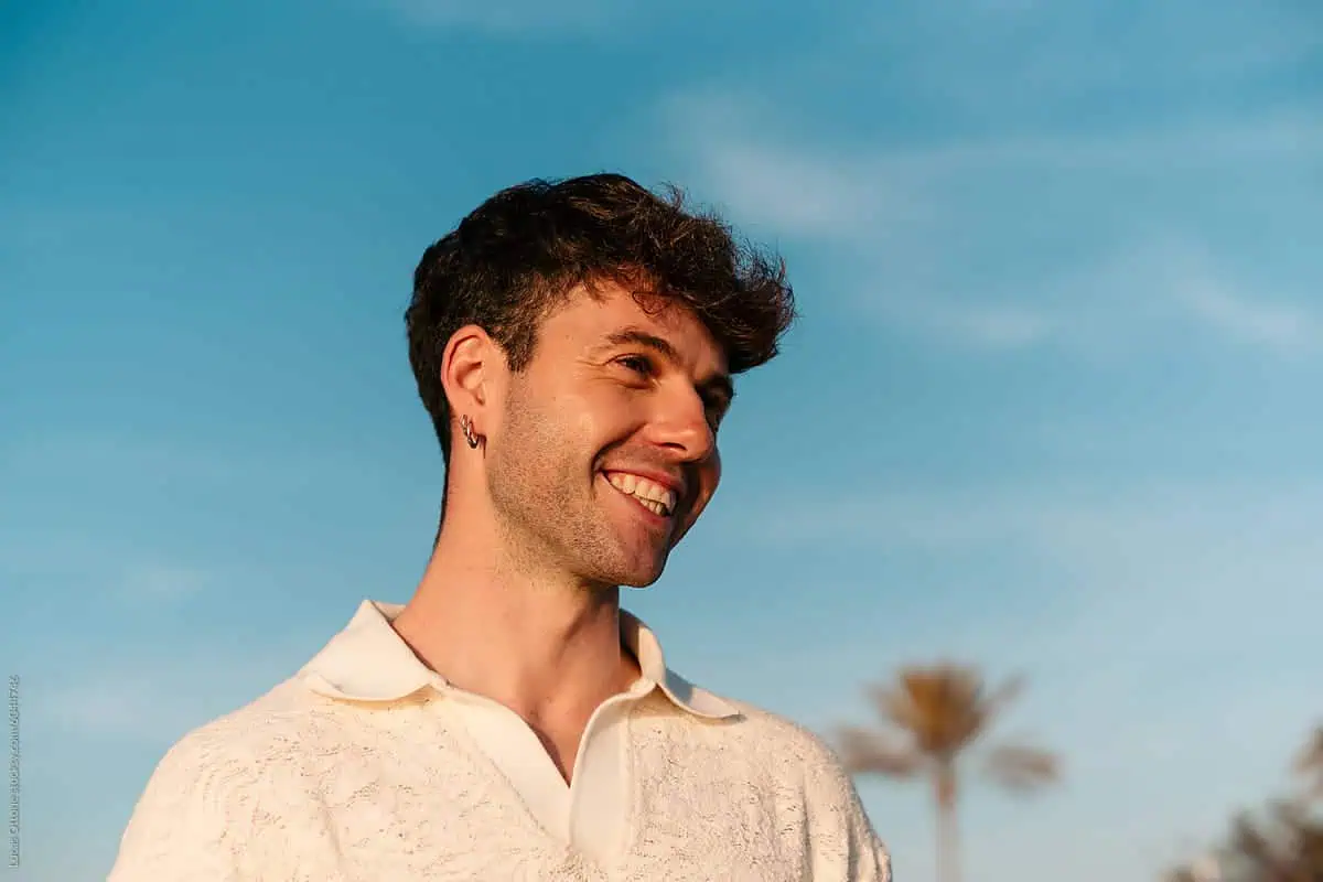 Young man smiling outdoors, adult ADHD assessment.