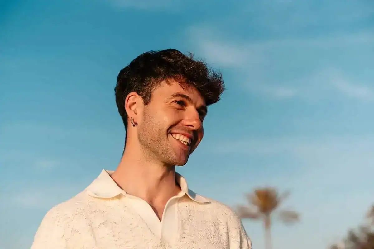 Young man smiling outdoors, adult ADHD assessment.